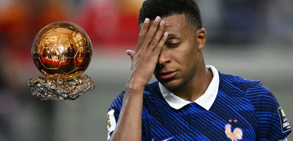 Kylian Mbappé se tenant le front près d'un Ballon d'Or