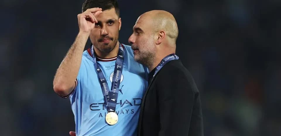 Joueur de Manchester City avec médaille discutant avec entraîneur