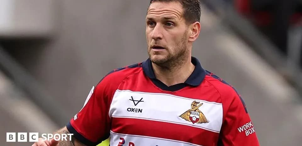 Joueur en maillot rouge et blanc sur le terrain