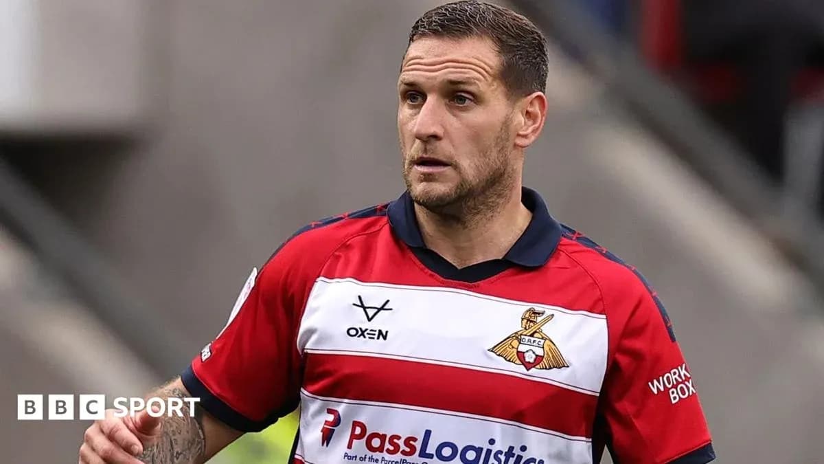 Joueur en maillot rouge et blanc sur le terrain