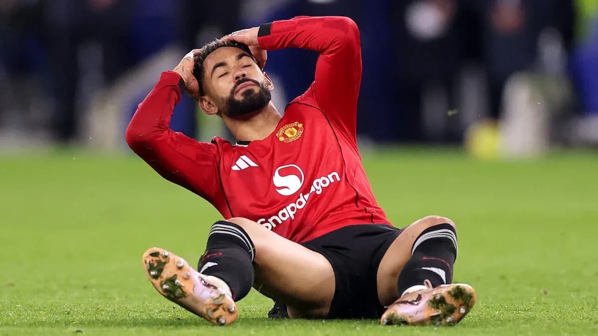 Joueur de Manchester United assis, se tenant la tête