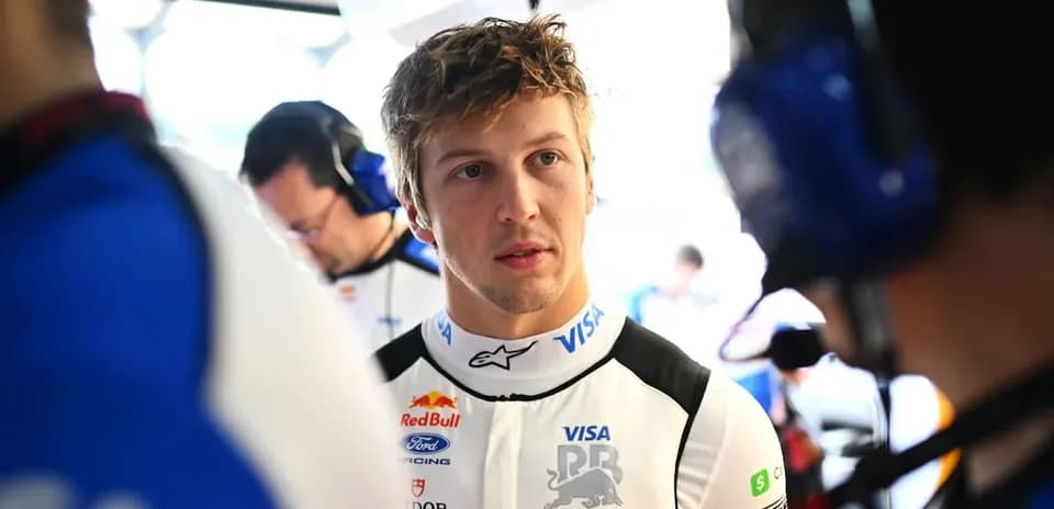 Pilote en combinaison discutant dans les stands