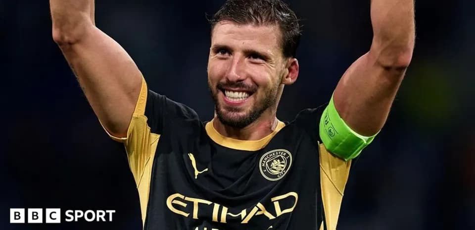 Joueur levant les bras, portant un maillot de Manchester City