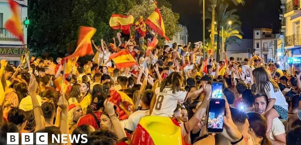 Foule célébrant avec des drapeaux espagnols la nuit
