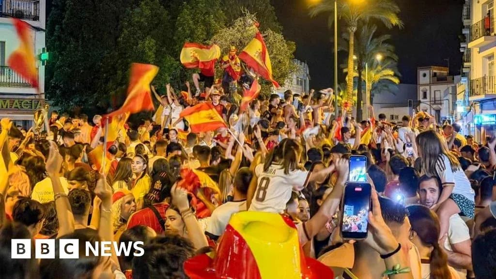 Foule célébrant avec des drapeaux espagnols la nuit