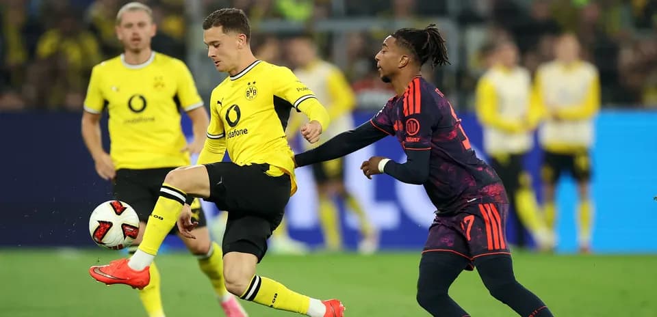 Joueur de Dortmund dribblant avec un adversaire en arrière-plan