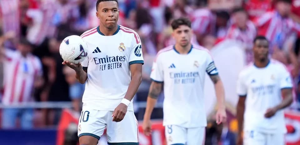 Kylian Mbappé tenant un ballon avec coéquipiers