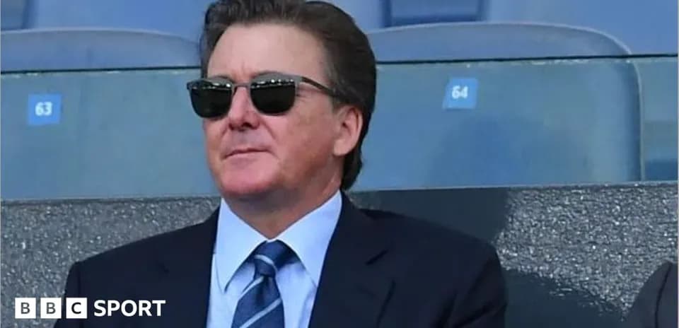 Homme en costume et lunettes de soleil dans les tribunes