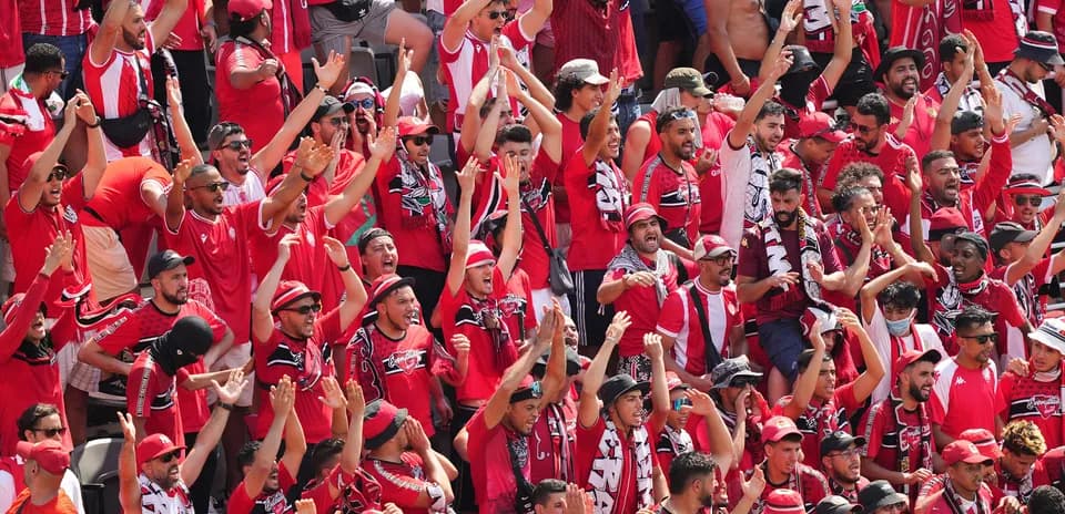 Supporters en rouge célébrant dans les tribunes