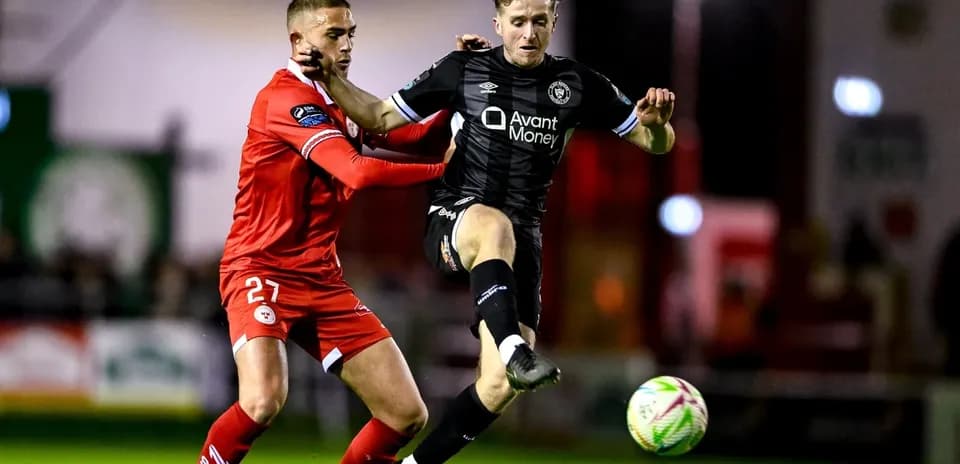 Joueur en noir dribblant sous pression d'un adversaire