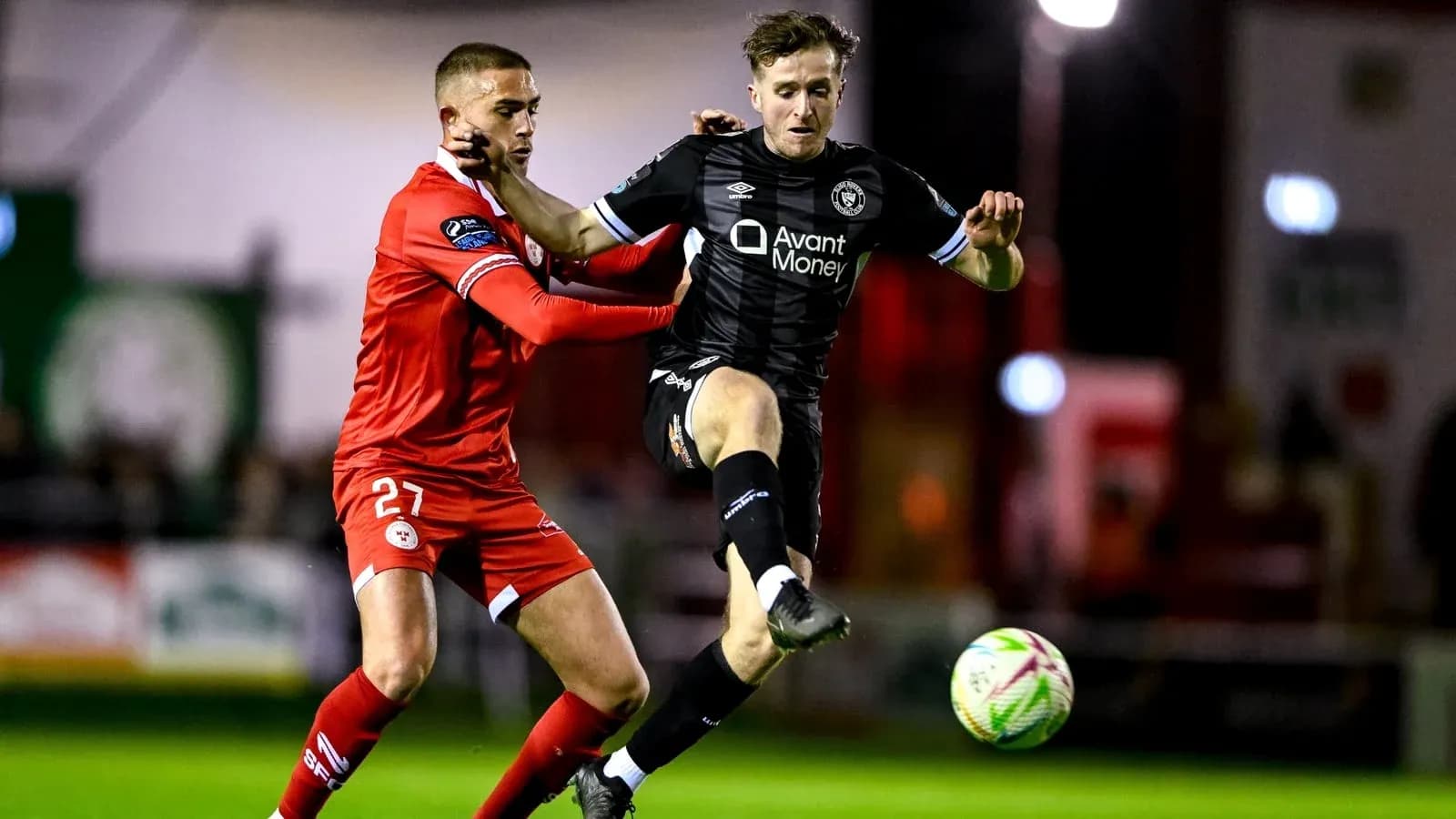 Joueur en noir dribblant sous pression d'un adversaire