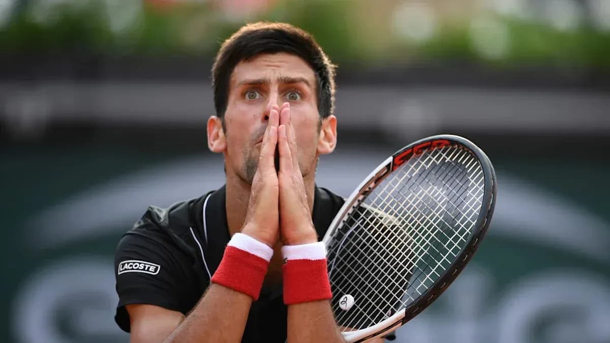Joueur de tennis tenant sa raquette avec les mains jointes