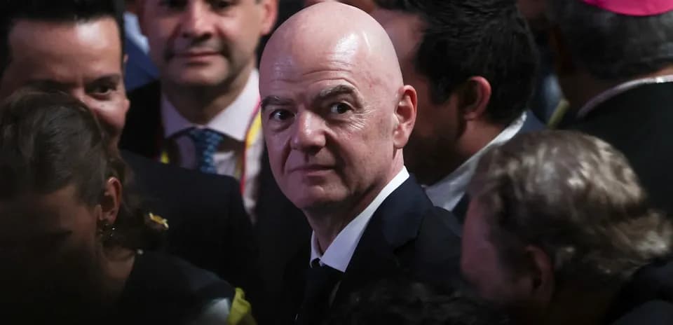 Person in suit surrounded by a crowd at event
