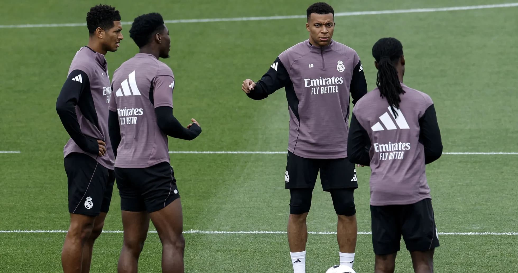 Quatre joueurs de football en discussion à l'entraînement