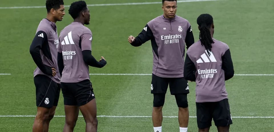 Quatre joueurs de football en discussion à l'entraînement