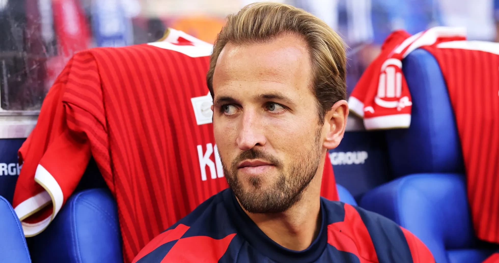 Joueur assis sur le banc avec maillot rouge