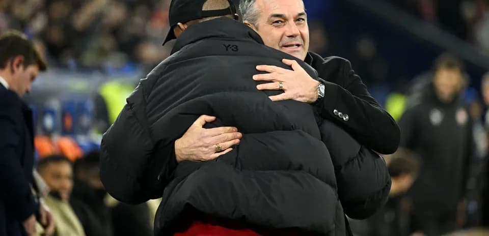 Deux entraîneurs se serrant dans les bras sur le terrain