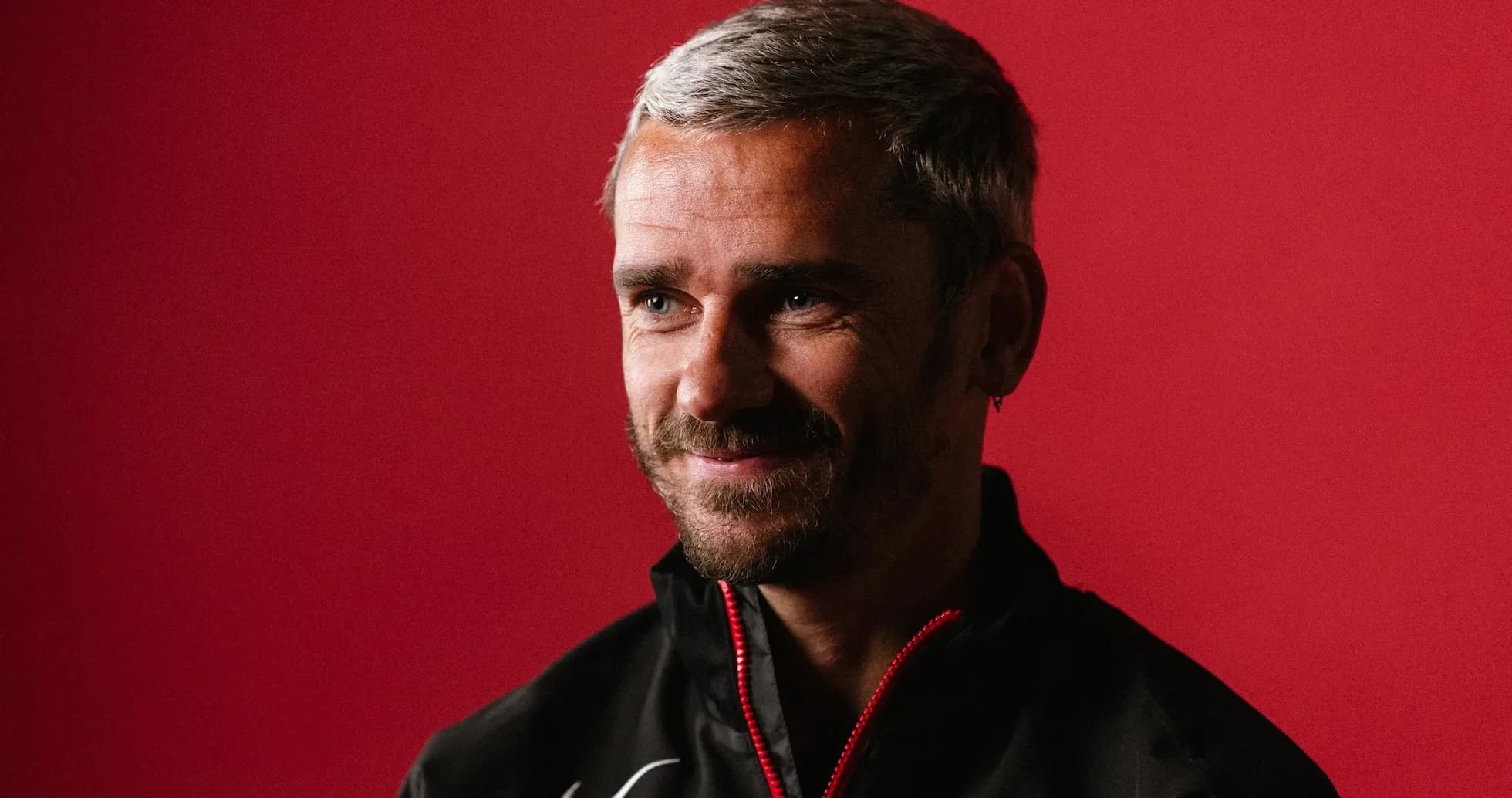 Homme souriant devant un fond rouge