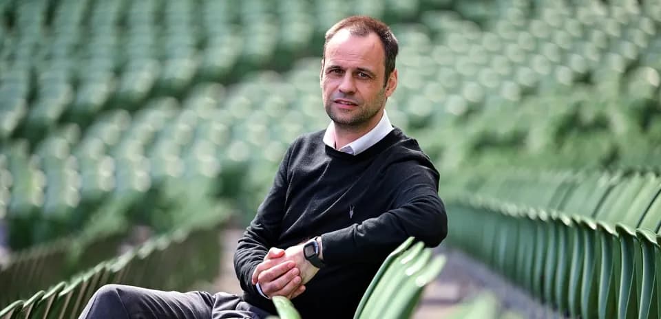 Homme assis sur des sièges vides dans un stade