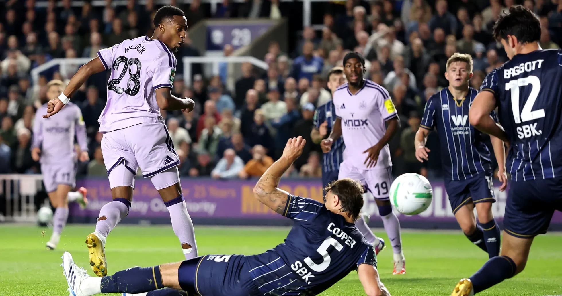 Joueur en violet dribblant un adversaire au sol