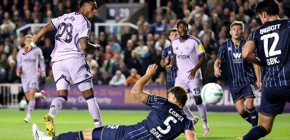 Joueur en violet dribblant un adversaire au sol