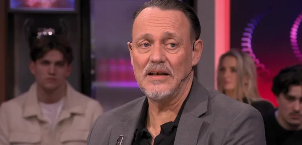 Homme parlant lors d'une émission avec public en arrière-plan