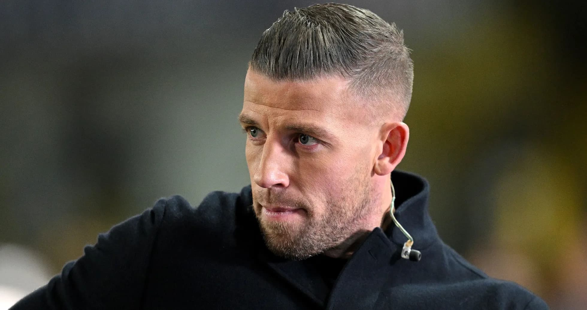 Homme avec une veste noire et une coiffure soignée
