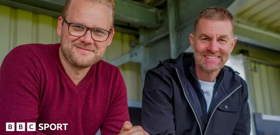 Deux hommes souriant assis en tribune de stade