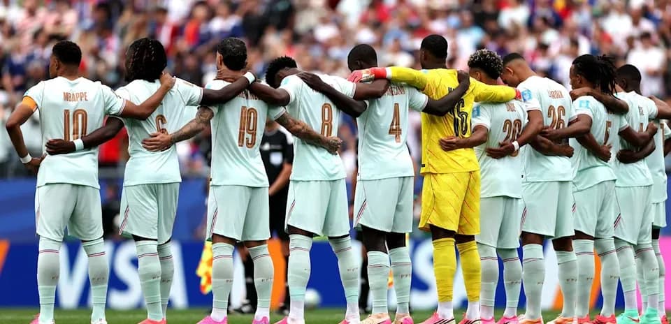 Équipe de football se tenant par les épaules avant le match