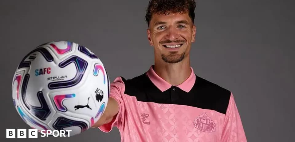 Joueur tenant un ballon de football en souriant
