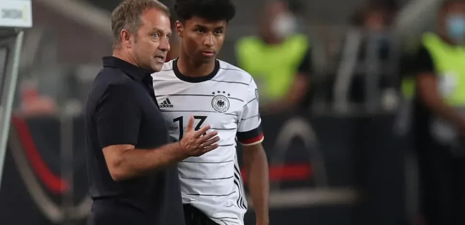 Entraîneur discutant avec un joueur allemand sur le terrain