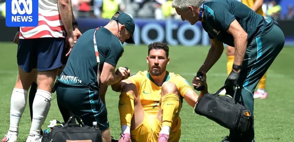 Joueur australien assis, soigné par le personnel médical