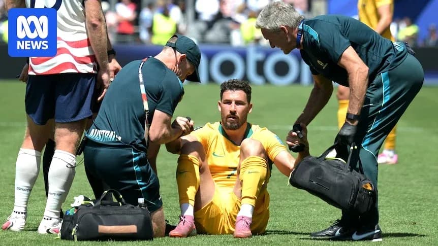 Joueur australien assis, soigné par le personnel médical
