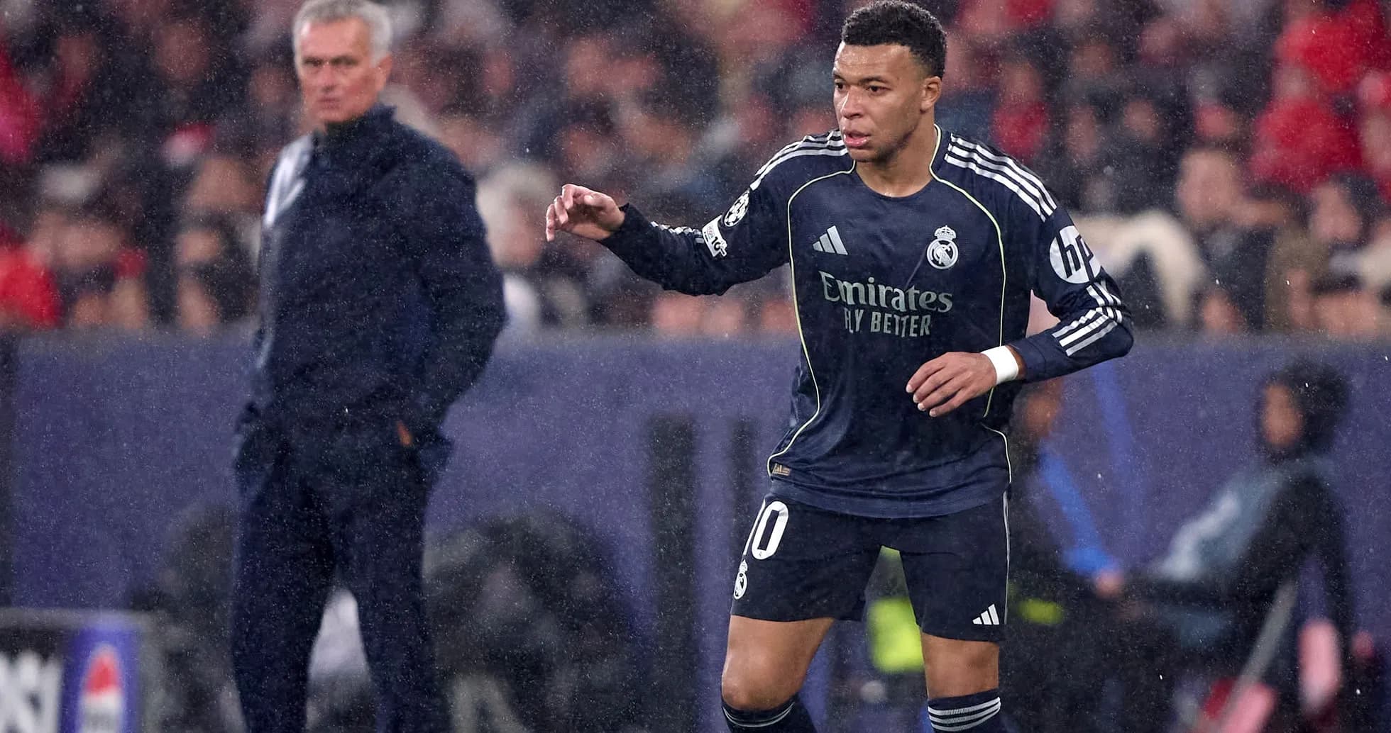 Kylian Mbappé dribbling during match with coach observing