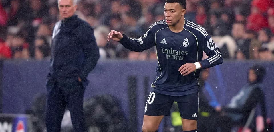 Kylian Mbappé dribbling during match with coach observing
