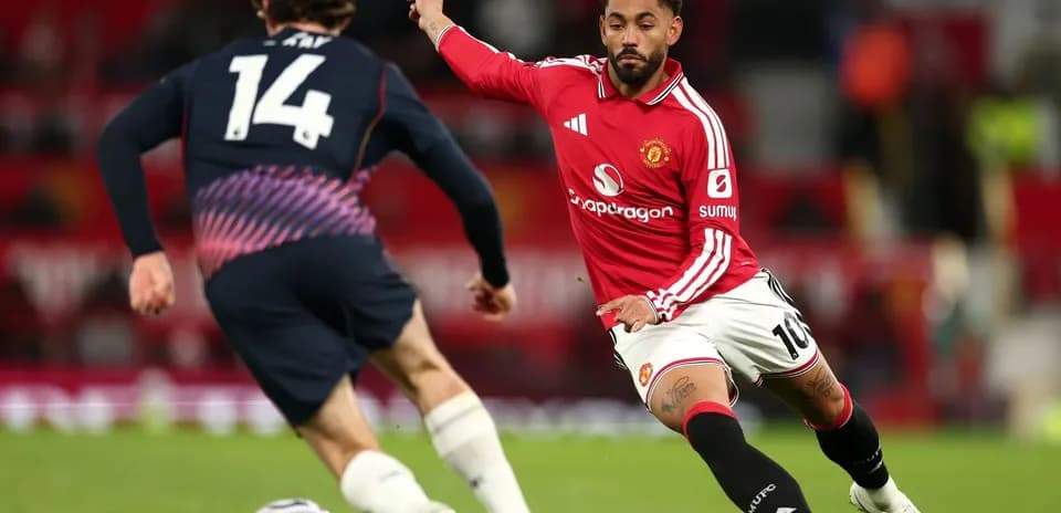 Joueur de Manchester United dribblant un adversaire