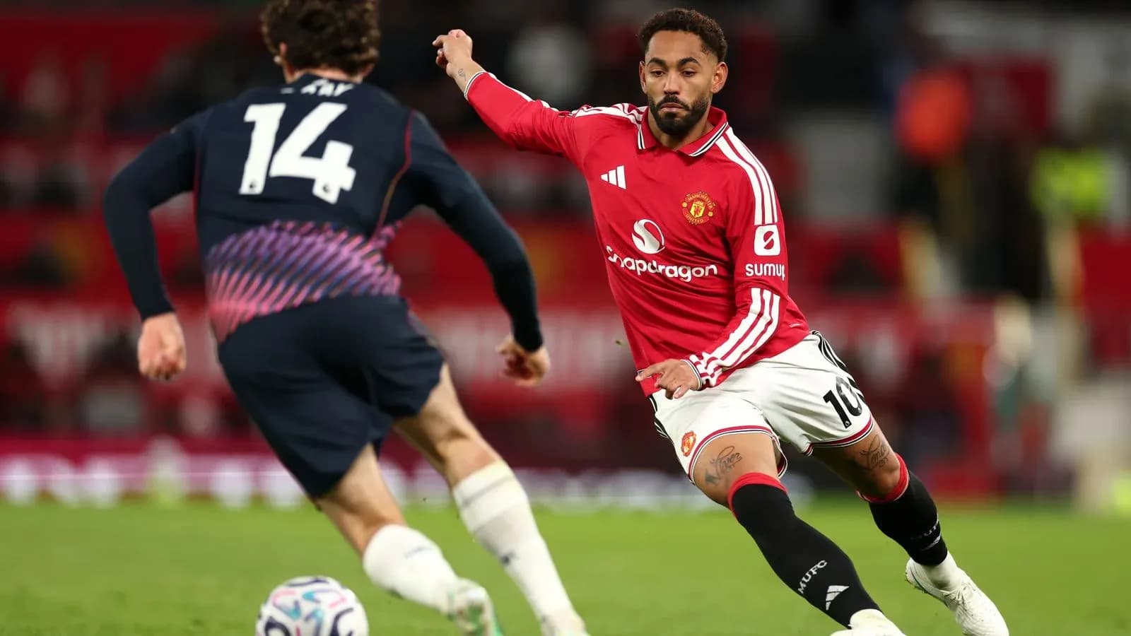 Joueur de Manchester United dribblant un adversaire