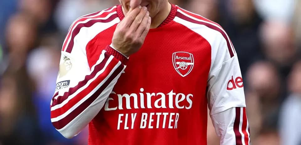 Joueur d'Arsenal touchant son nez sur le terrain