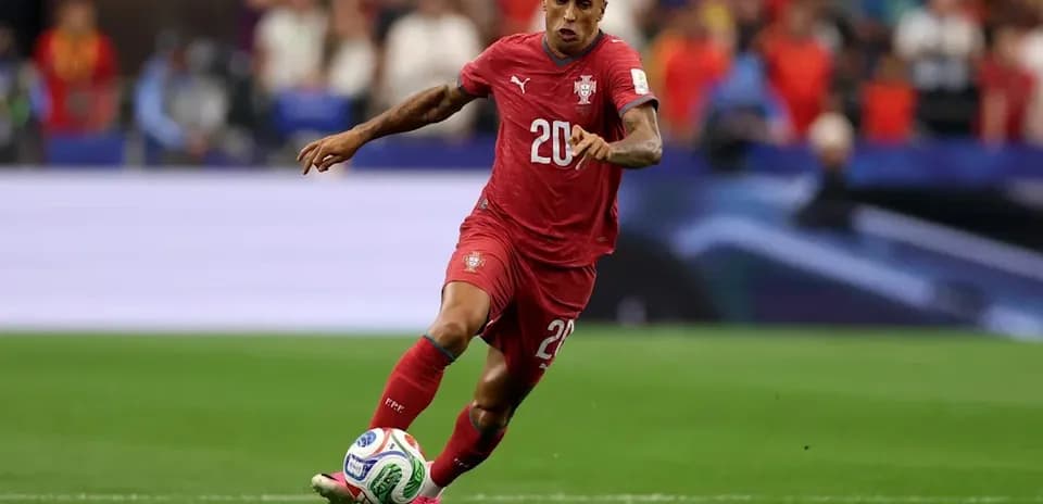 Joueur du Portugal dribblant le ballon sur le terrain