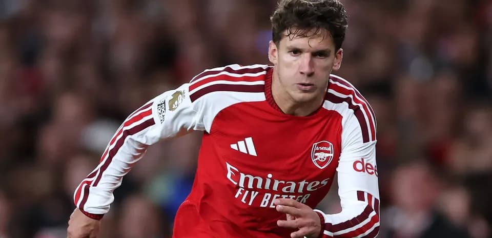 Joueur d'Arsenal courant avec le ballon sur le terrain