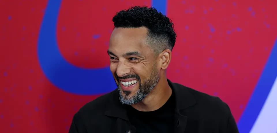 Homme souriant lors d'un événement médiatique