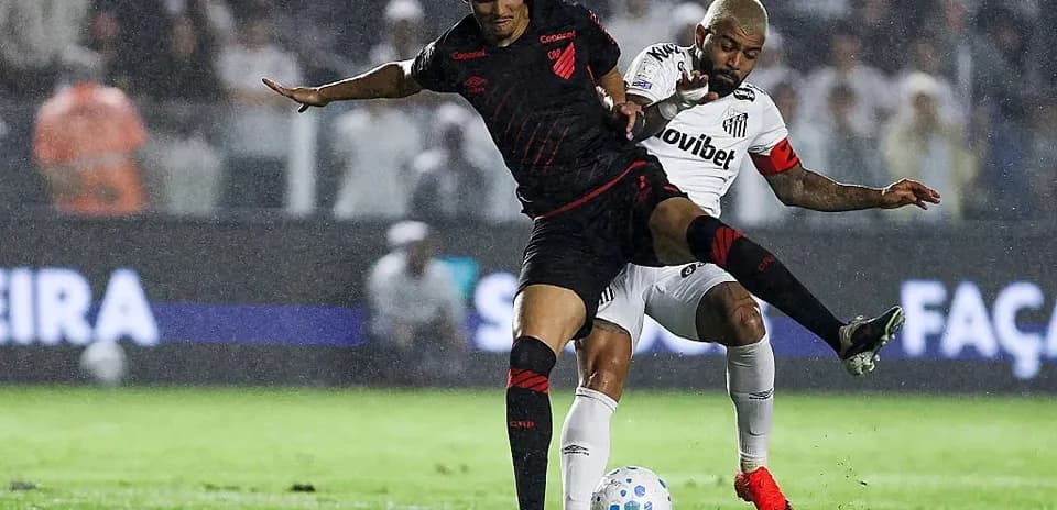 Joueur dribblant sous la pluie lors du match