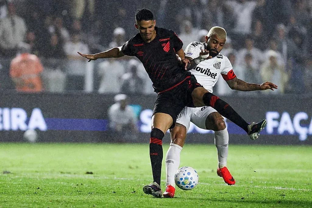 Joueur dribblant sous la pluie lors du match