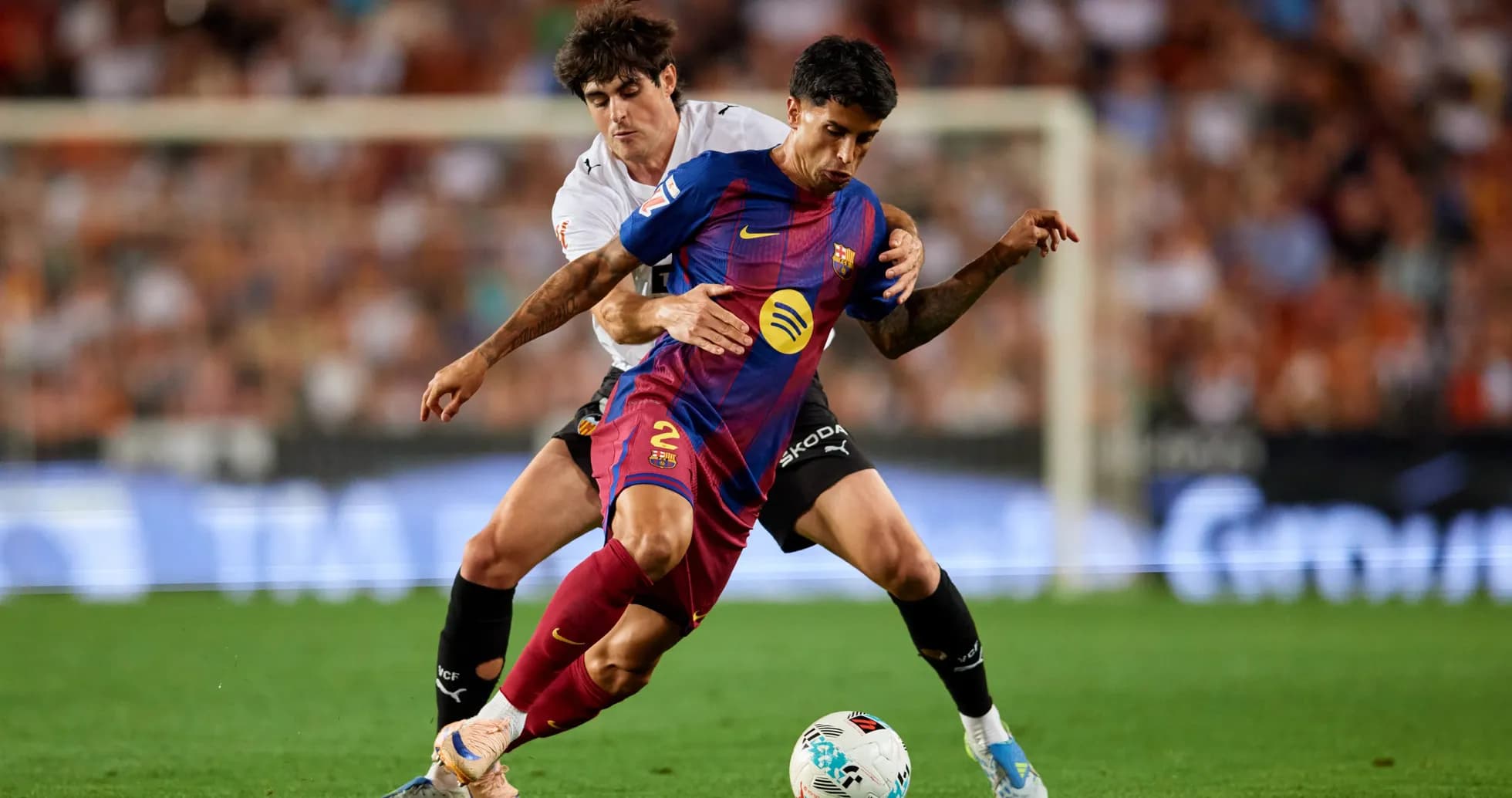Joueur de Barcelone dribblant sous pression d'un adversaire