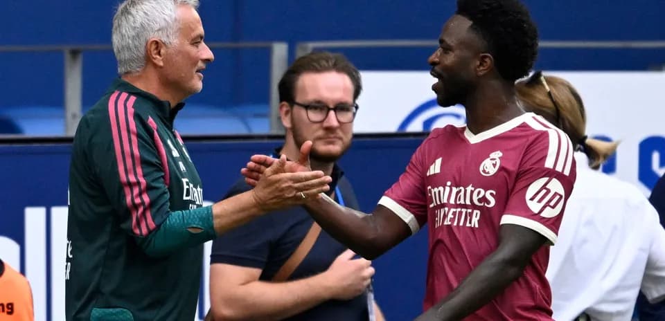 Entraîneur et joueur se serrant la main sur le terrain