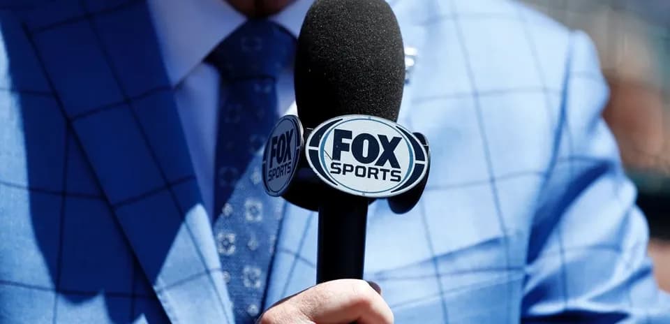 Microphone with FOX Sports logo held by person