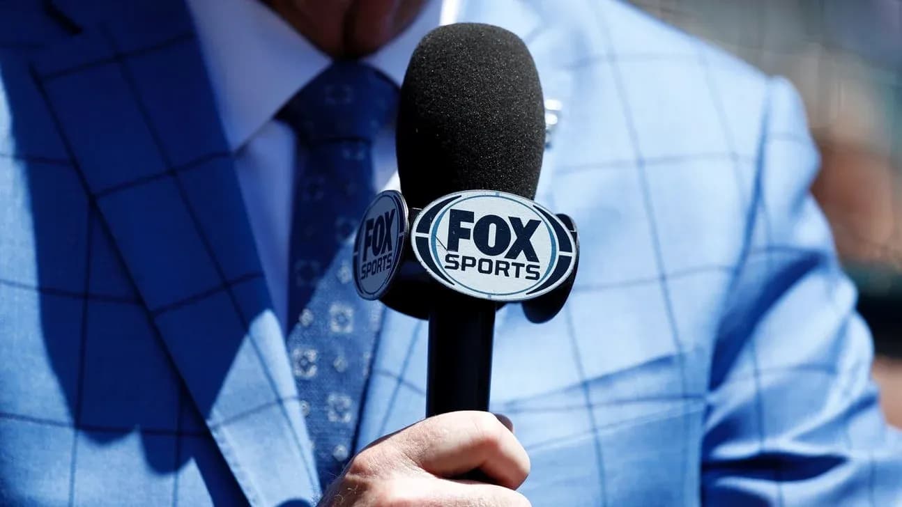 Microphone with FOX Sports logo held by person