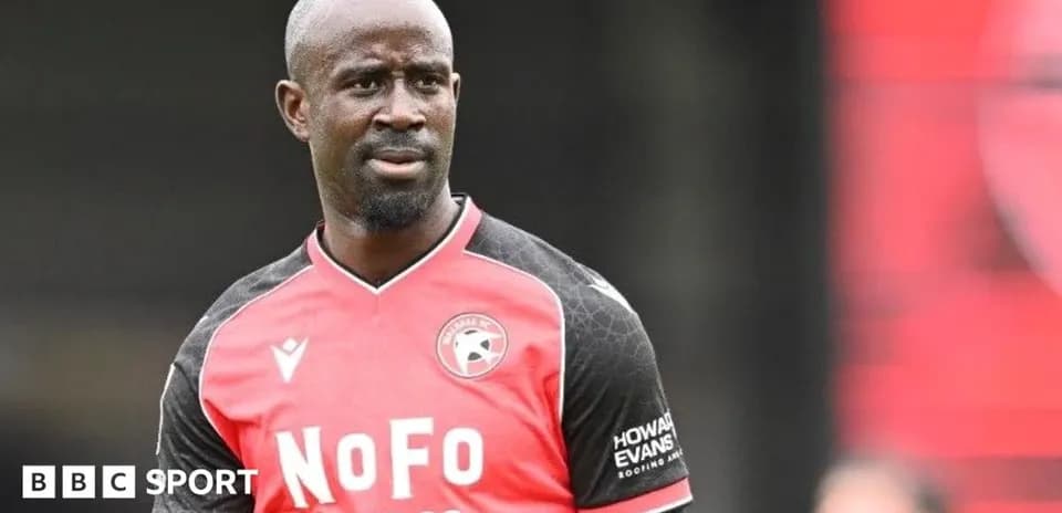 Joueur en maillot rouge et noir sur le terrain