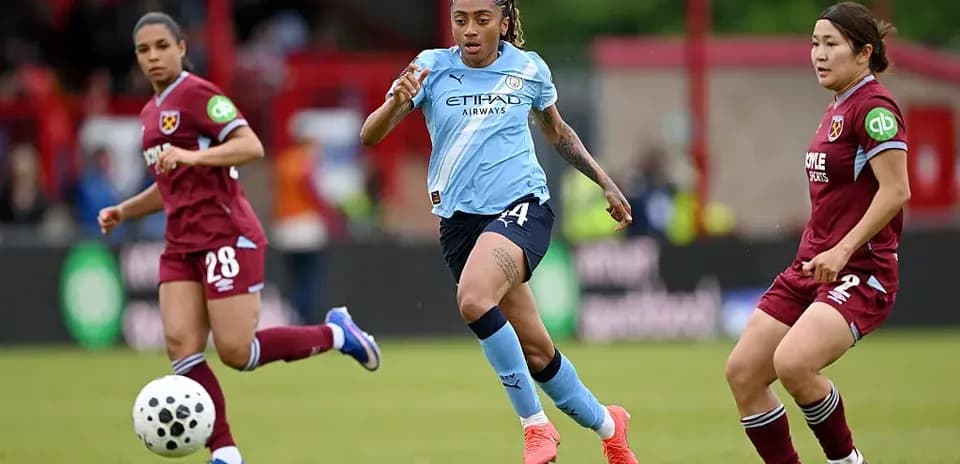 Joueuse de Manchester City dribblant le ballon sur le terrain