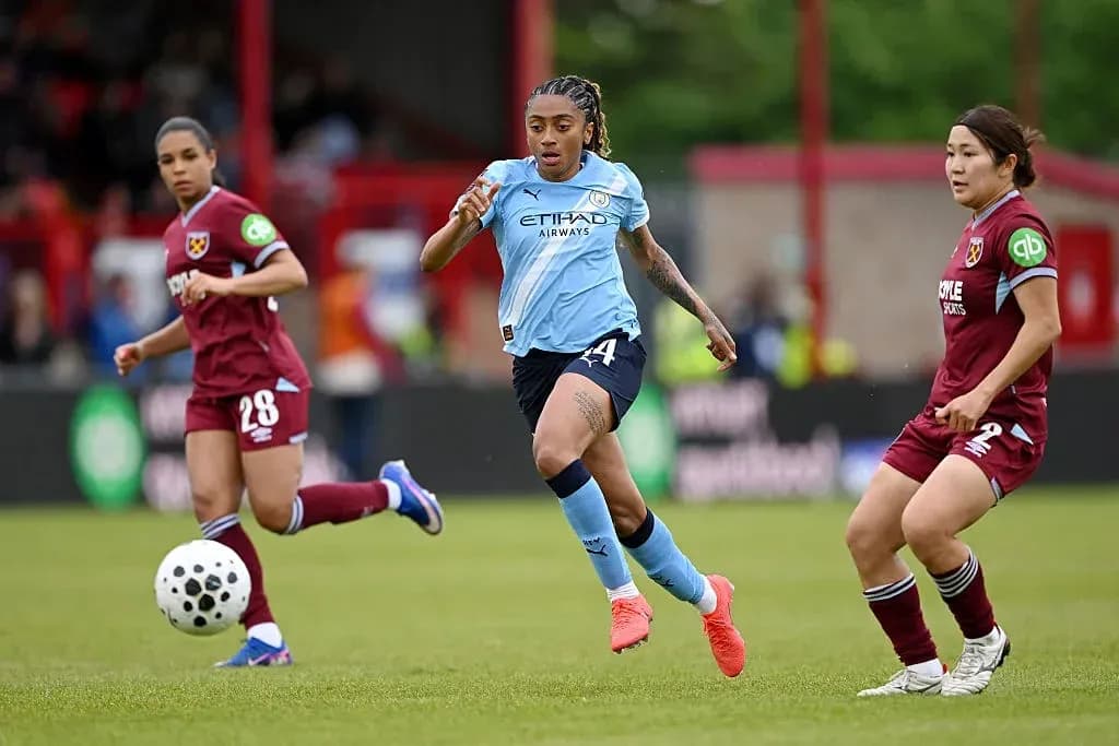 Joueuse de Manchester City dribblant le ballon sur le terrain